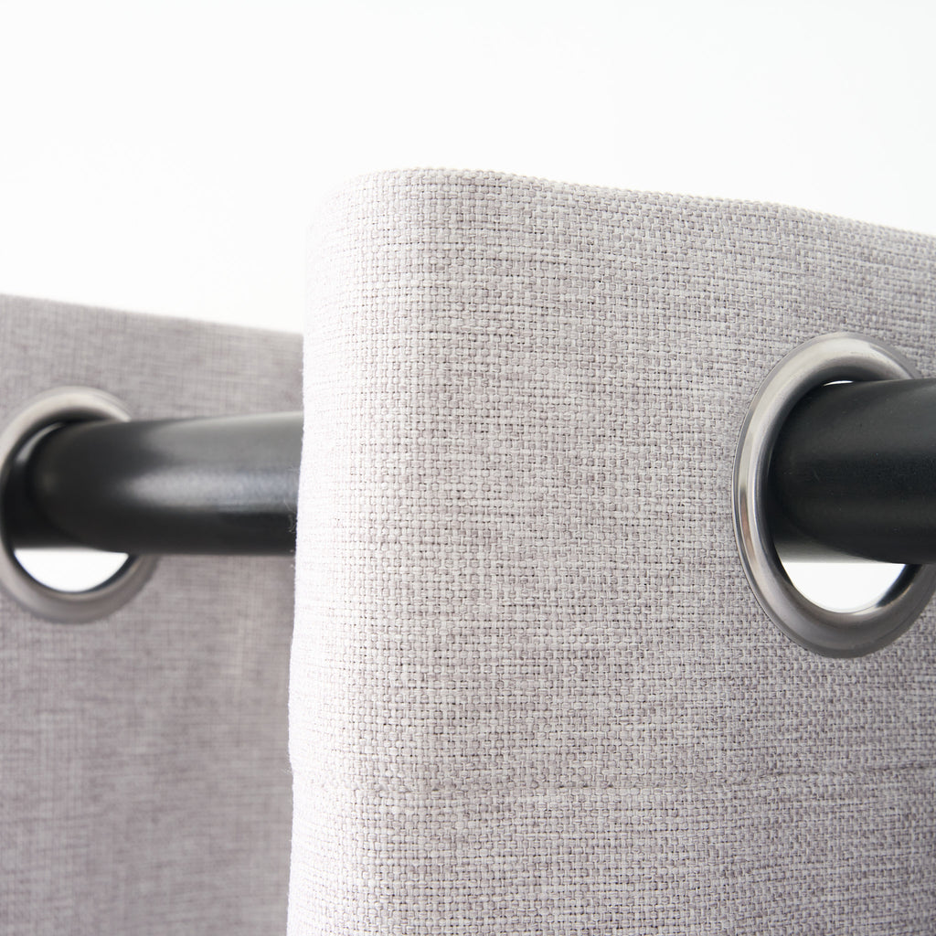 Close-up of the eyelet grommets on the Dakota curtain in pearl grey, threaded onto a curtain rod