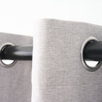 Close-up of the eyelet grommets on the Dakota curtain in pearl grey, threaded onto a curtain rod
