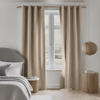Almond Dakota block out curtains framing a bedroom window beside a bed with a wooden nightstand
