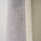 Close-up of the Dakota curtain's grey blockout lining against the almond face fabric and seam edge