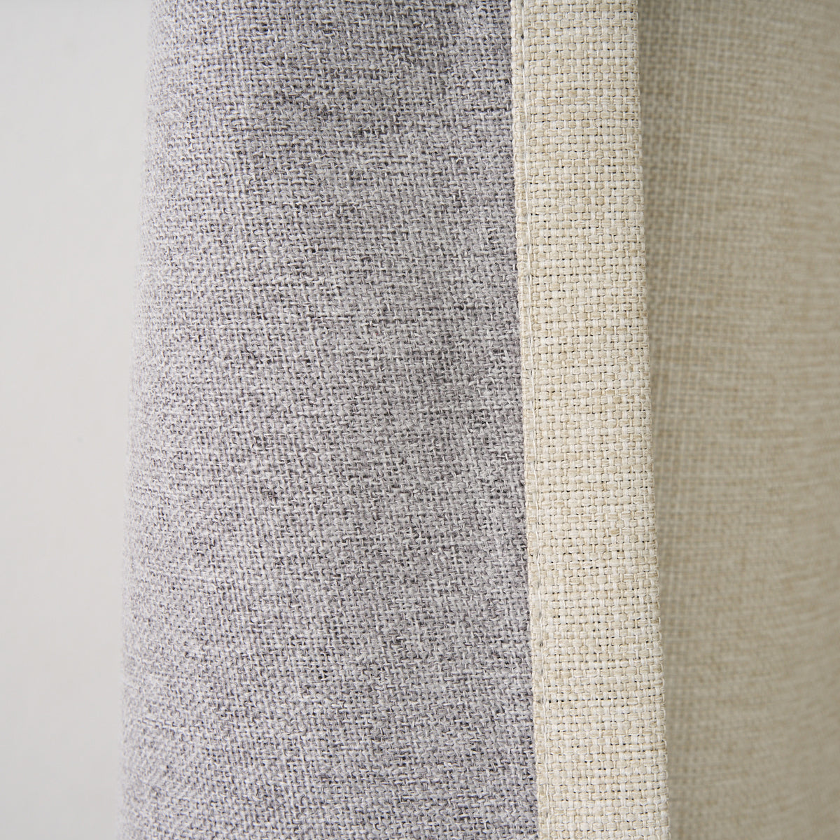 Close-up of the Dakota curtain's grey blockout lining against the almond face fabric and seam edge