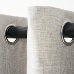 Close-up of the eyelet grommets on the Sinclair curtain in creme grey, threaded onto a curtain rod