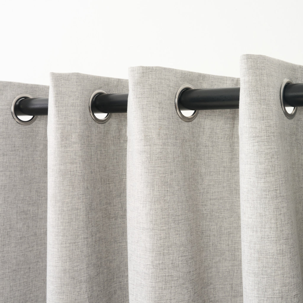 Close-up of several eyelet grommets along the top of the Sinclair curtain in creme grey