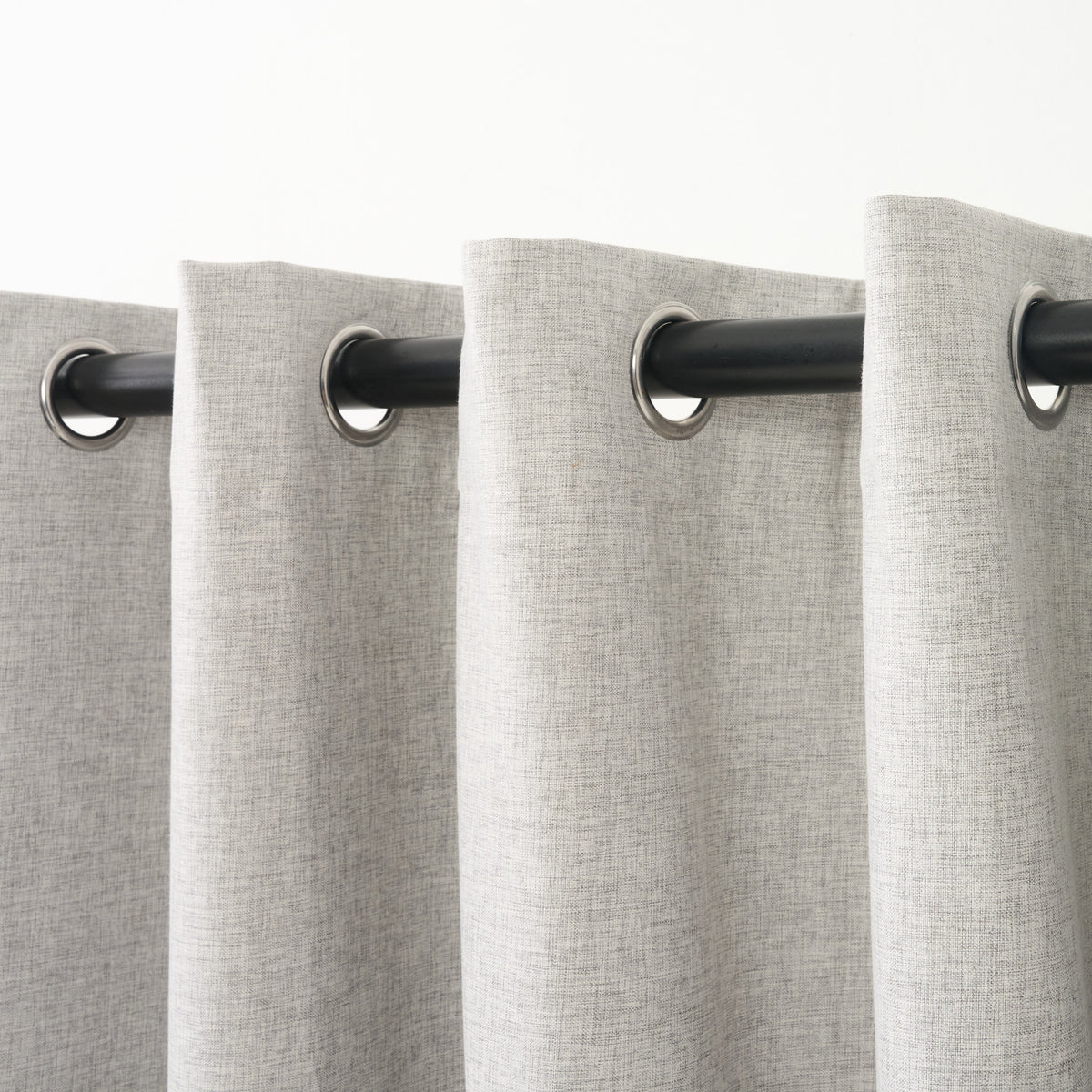 Close-up of several eyelet grommets along the top of the Sinclair curtain in creme grey
