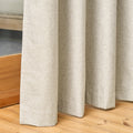Close-up of the Sinclair curtain's hem pooling on a wooden floor in light stone