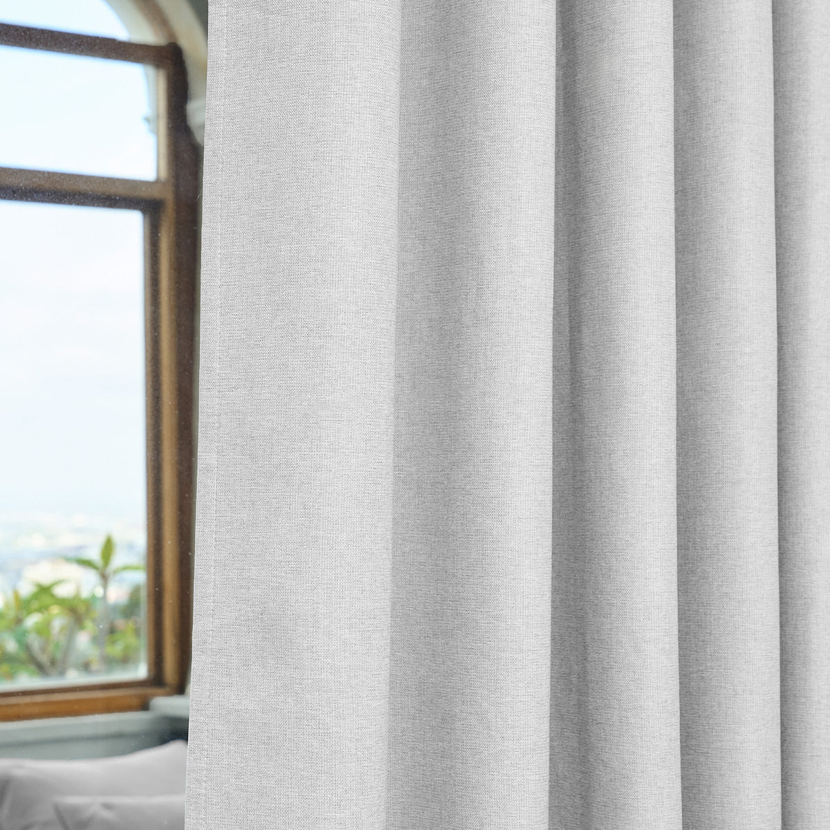 Close-up of the eyelet grommets on the Dakota curtain in pearl grey, threaded onto a curtain rod